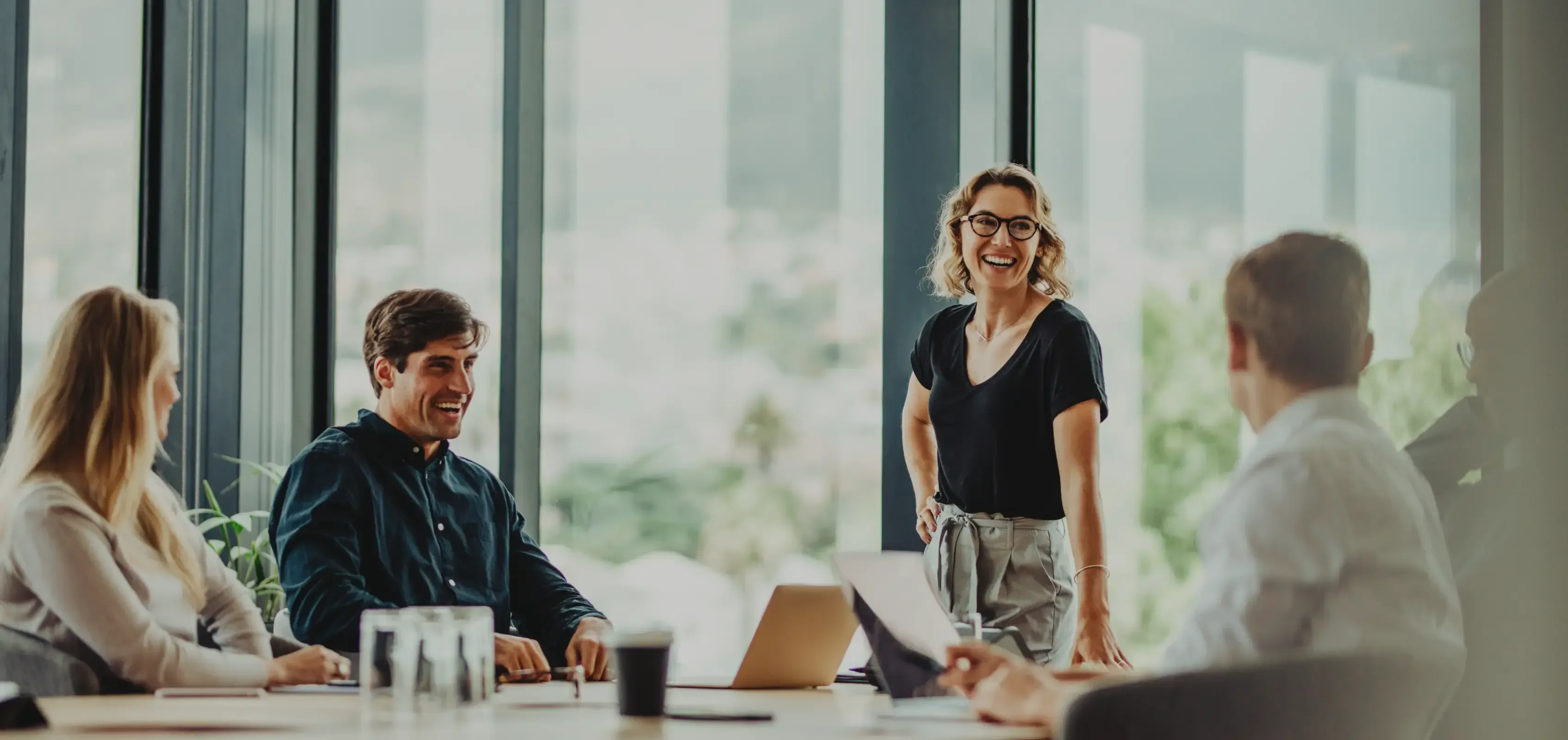Female lawyer leading a business meeting in a glass conference room.