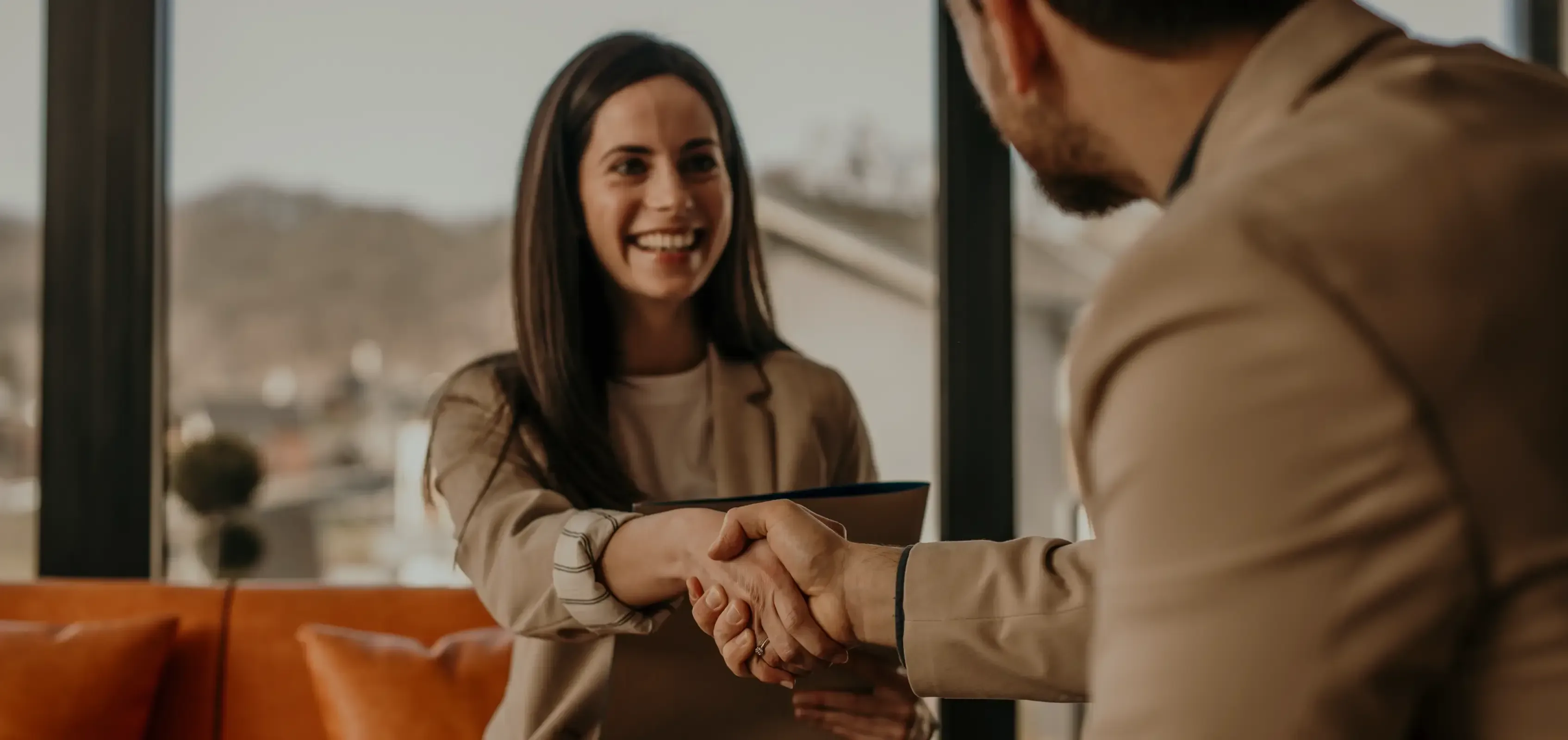 Smiling business woman shaking hands with client.