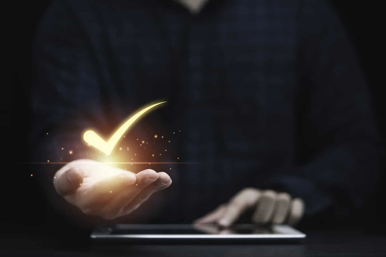 A chief legal officer holds up a checkmark representing assurance in his legal department’s compliance and regulation practices.