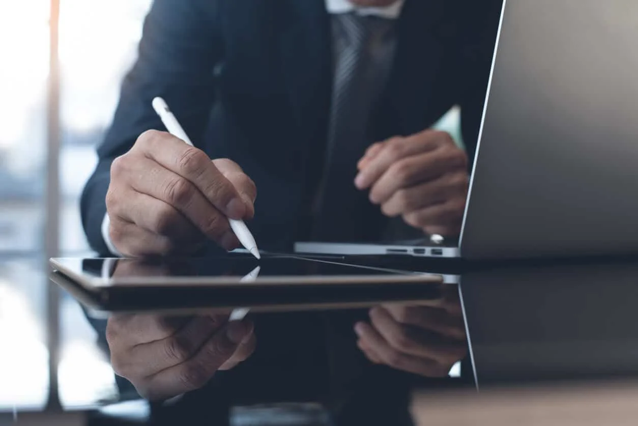 An in-house attorney reviews and marks up a contract prepared using automated legal drafting techniques.