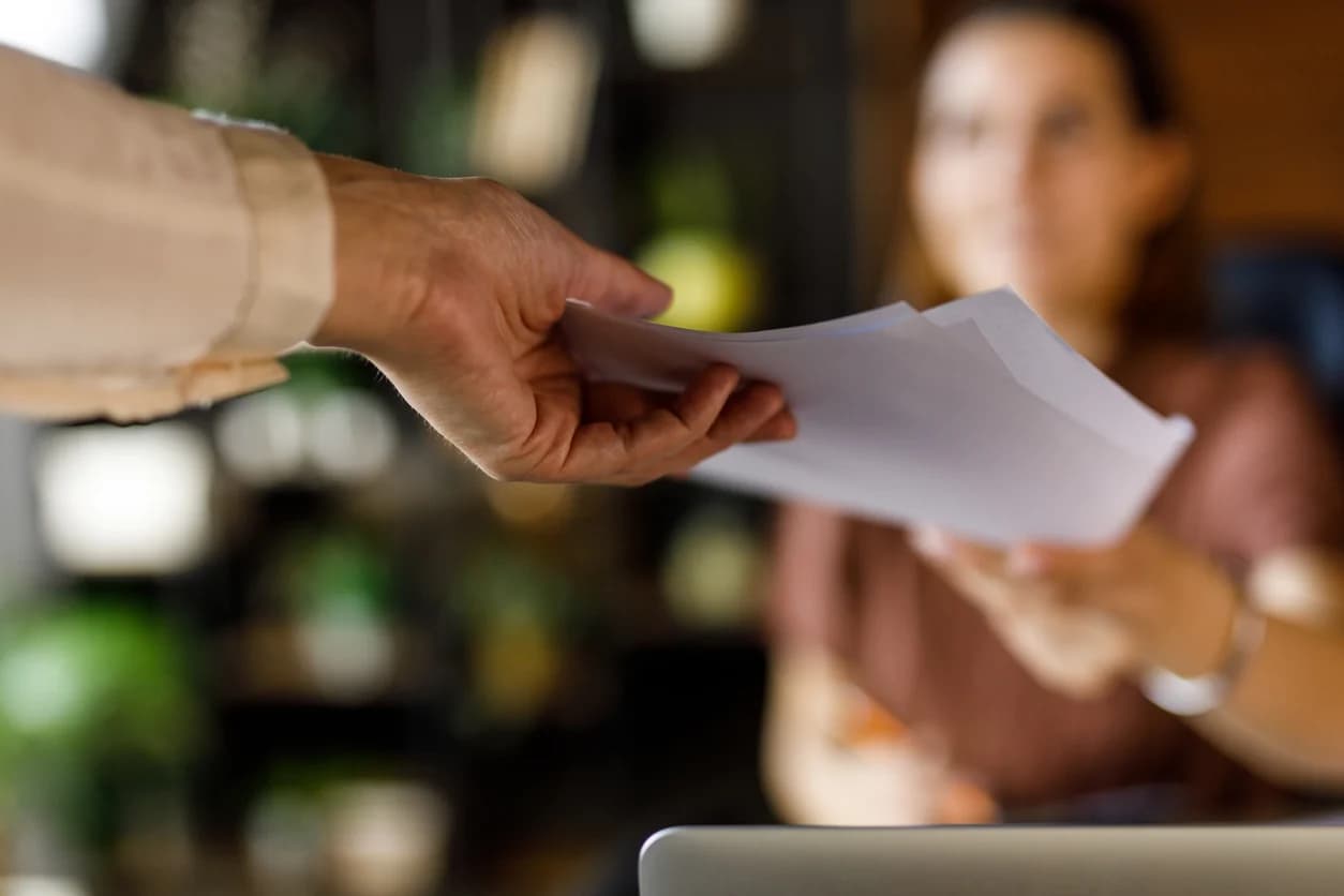 A man hands off contract to a woman during contract lifecycle management